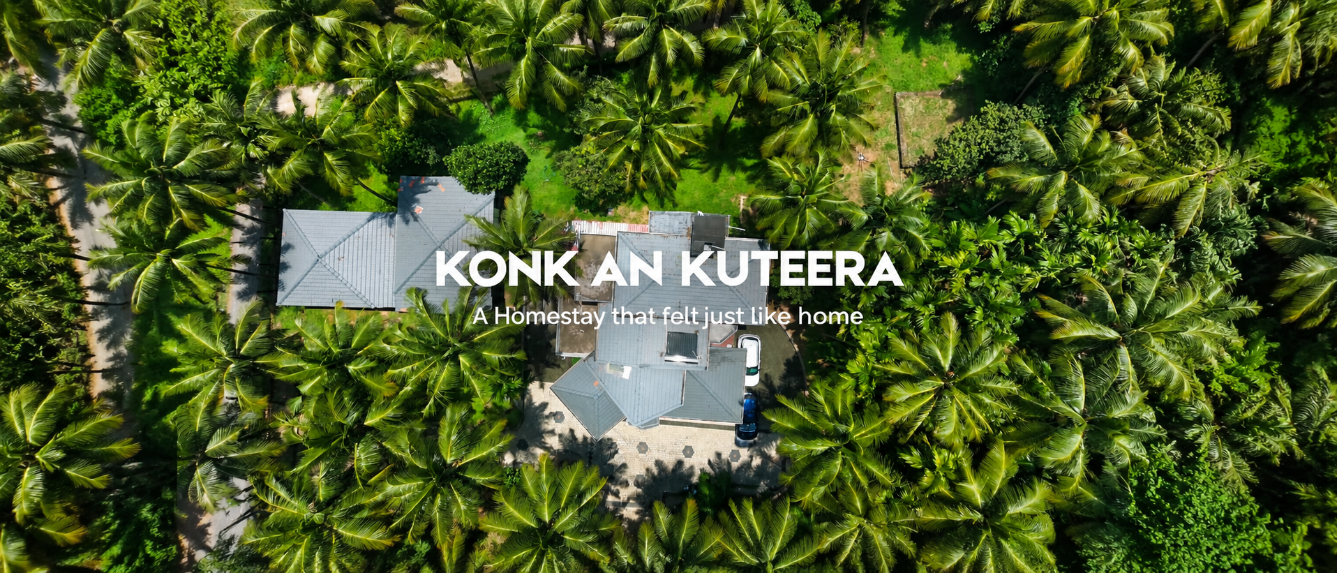 Sunlit exterior of Konkan Kuteera heritage retreat with terracotta roof tiles and timber verandas overlooking the Panchangavali river